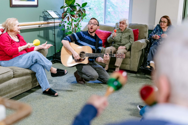 Eric leading music therapy in an assisted living facility with memory care