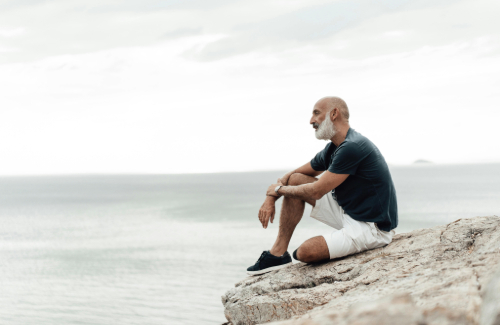 Man sitting by the ocean gaining mental clarity during retirement